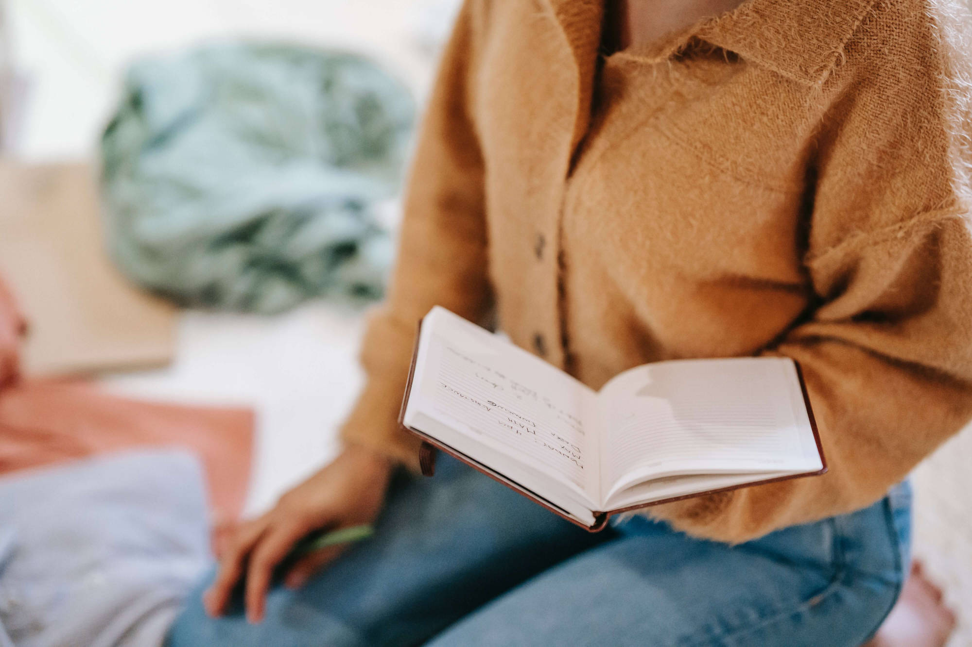 Eine Frau studiert in einem Notizbuch die Inhalte eines Gutscheins